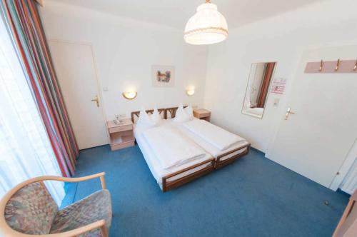 巴德加斯坦Hotel Goethehof的配有一张床和一把椅子的酒店客房