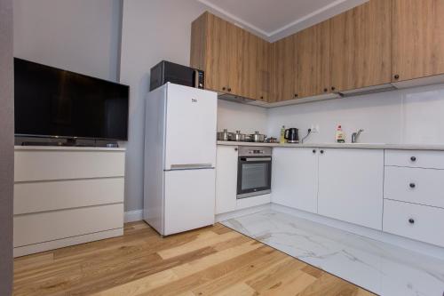 比亚韦斯托克CR Apartament w sercu miasta Lipowa 1的厨房配有白色家电和木制橱柜