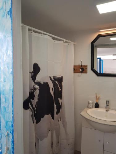 圭马尔Sueño de Mar的浴室设有黑色和白色的牛帘