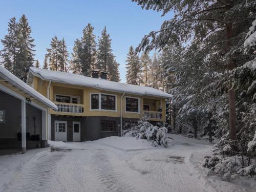 拉赫登佩拉Holiday Home Vaarapirtti - tähti by Interhome的一座黄色的房子,地面上积雪