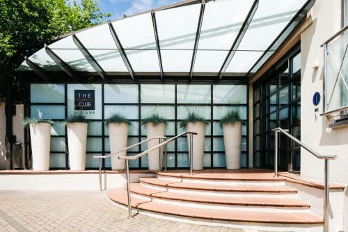 圣赫利尔泽西经典英国泽西俱乐部酒店&SPA的前面有楼梯的玻璃建筑