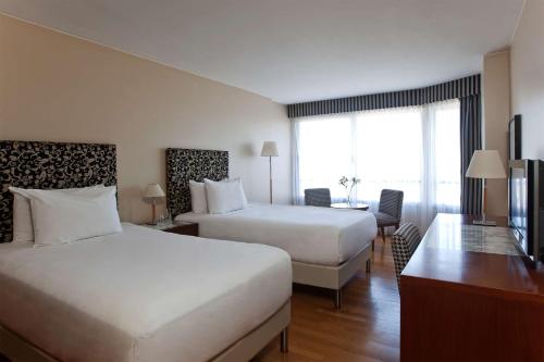科尔多瓦科尔多瓦全景NH酒店的酒店客房配有两张床和一张书桌
