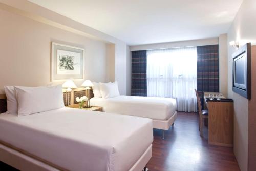 科尔多瓦科尔多瓦乌尔巴诺NH酒店的酒店客房设有两张床和电视。