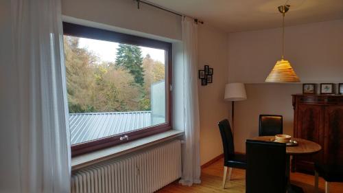 沃尔普斯韦德Ferienwohnung Gartenblick的一个带桌子的房间和饭厅的大窗户