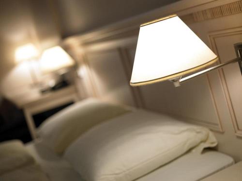 坎普-林特福特赌场公园酒店的一间卧室配有一张床,上面有灯