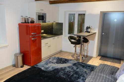 维也纳Auszeit Vienna Wellness Apartment的一间厨房,内设红色冰箱和一张桌子