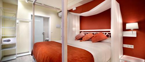 毕尔巴鄂Pensión Plaza Nueva的一间卧室配有带橙色墙壁的天蓬床