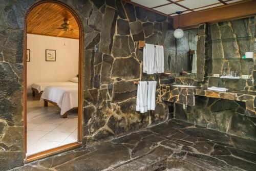 圣何塞科斯塔韦德公寓式酒店的浴室设有石墙和镜子