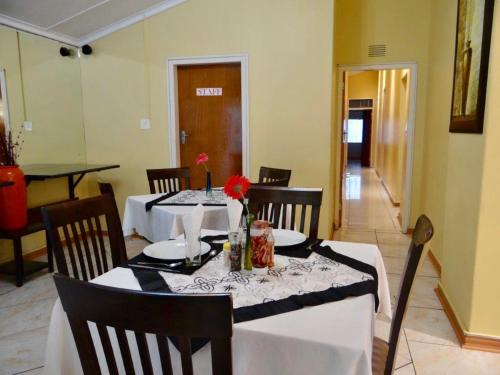 乌姆塔塔Lilliz Guest House的一间用餐室,配有一张带白色桌布的桌子