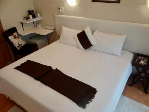 乌姆塔塔Lilliz Guest House的卧室配有一张白色的床,上面有黑色毯子