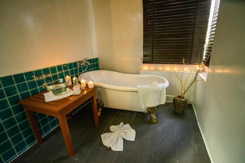 查汶查汶海滩度假酒店的带浴缸和蜡烛桌的浴室