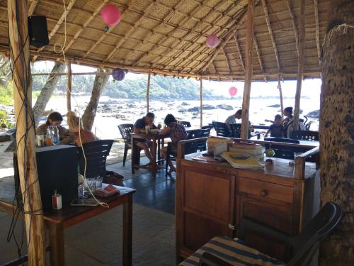 ColaCola Beach Sunset Bay的一群坐在餐厅桌子上的人