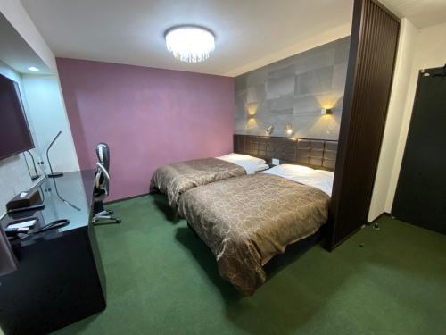 伊万里市HOTEL WIN的酒店客房,设有两张床和一盏灯