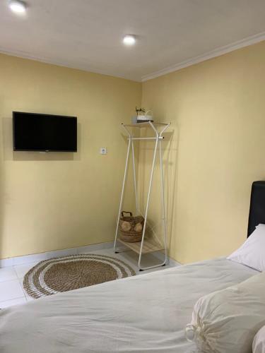 斯勒曼Omah Kebon Kalasan的卧室配有一张床,墙上配有电视