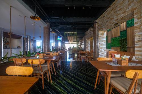 坎古蝴蝶回声海滩酒店的餐厅设有木桌、椅子和砖墙