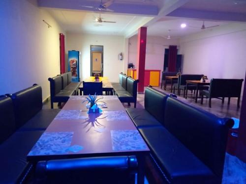 KushinagarHotel the Ideal的一间带长桌和椅子的用餐室