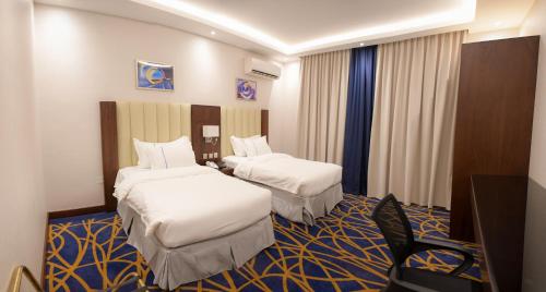 吉赞Quba Inn Hotel的酒店客房设有两张床和电视。