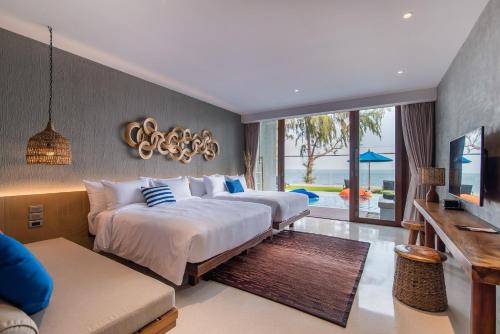 七岩Lullaby The Sea Hua Hin的一间酒店客房,设有两张床和电视