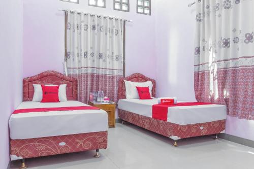 井里汶RedDoorz Syariah @ Puri Kalijaga Street的红色和白色的客房内的两张床
