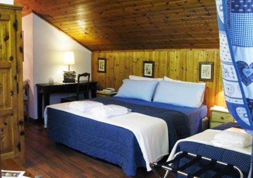 普雷圣迪迪埃布卡奈维酒店的一间卧室配有两张带蓝白色床单的床