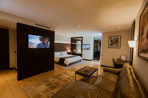 地拉那Privilege Hotel & Spa的带沙发、床和电视的客厅