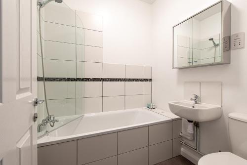 罗切斯特Riverside Luxury Apartment的白色的浴室设有浴缸和水槽。