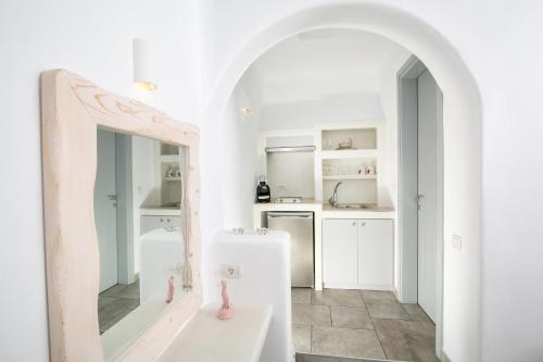 伊亚安尼摩沙别墅酒店的白色的厨房配有镜子和水槽