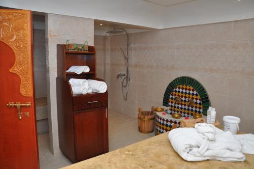 非斯阿克罗斯酒店及Spa的带淋浴的浴室以及带毛巾的壁炉。