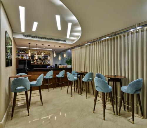 贝鲁特Sodeco Suites的一间带桌椅的餐厅和一间酒吧