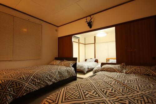 札幌札幌ドーム前ハウス Sapporodome front house的一间卧室配有两张床和镜子