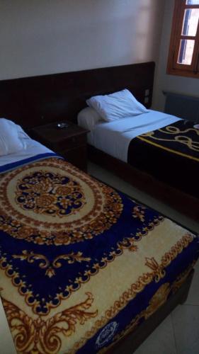 伊穆泽尔杜坎达Hôtel chahrazad的两张睡床彼此相邻,位于一个房间里
