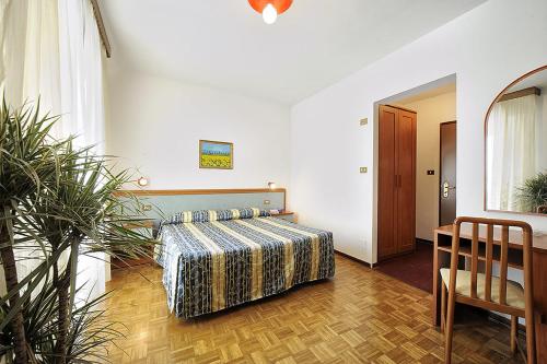 波雷塔泰尔梅贝尔图思酒店的卧室配有1张床、1张桌子和1把椅子