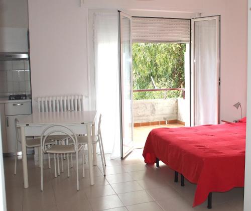 迪亚诺马里纳Residenza Abbo的厨房以及带桌子和床的用餐室。