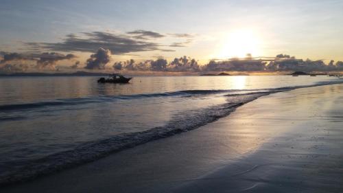 普拉兰大安塞区Destination Self-Catering的日落时分在海滩上乘船