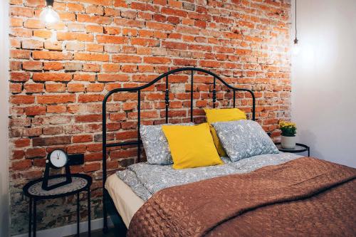 克拉科夫Cosy Apartment的一间卧室设有砖墙和一张床