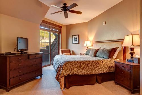 布雷肯里奇Crystal Peak 7403的一间卧室配有一张床、一台电视和一个梳妆台