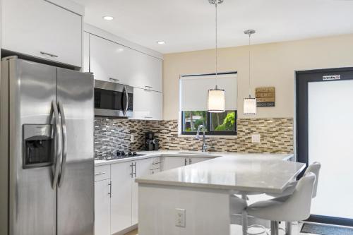劳德代尔堡Alani Bay Condos的厨房配有白色橱柜和不锈钢冰箱