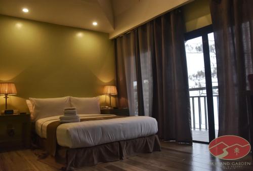 碧瑶Skyland Garden Hotel and Resort的一间卧室设有一张床和一个大窗户