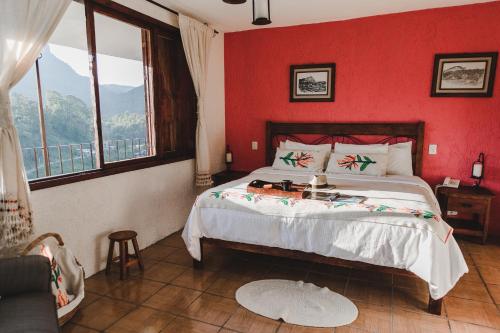 TlatlauquitepecHotel San Jorge的一间卧室设有一张红色墙壁的大床
