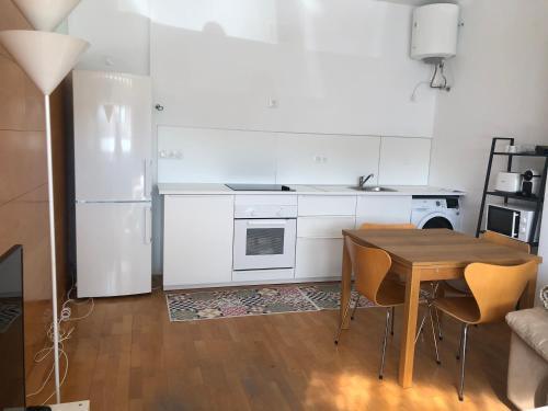 阿利坎特Estudio acogedor renfe的厨房配有木桌和白色冰箱。