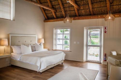塔尔巴赫Rijk's Wine Estate & Hotel的卧室配有白色的床和2扇窗户。