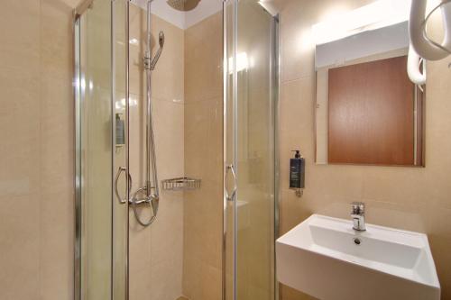 约阿尼纳Ali Pasha Hotel的带淋浴、盥洗盆和盥洗盆的浴室