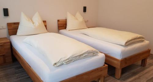 MoosGasthaus Pension Hörner的配有2张床的带白色床单和枕头的客房