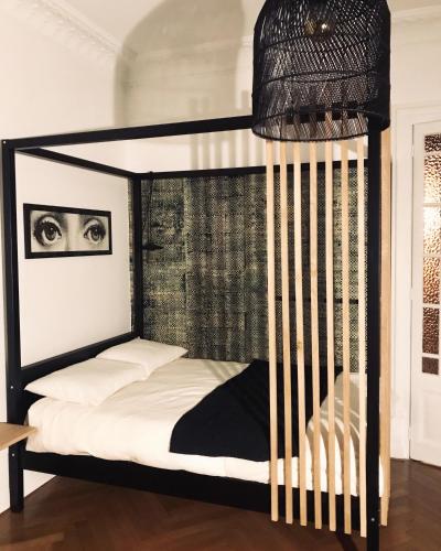 安锡L’Appartement des Glières Annecy centre的一间卧室配有一张带白色床单的黑色双层床