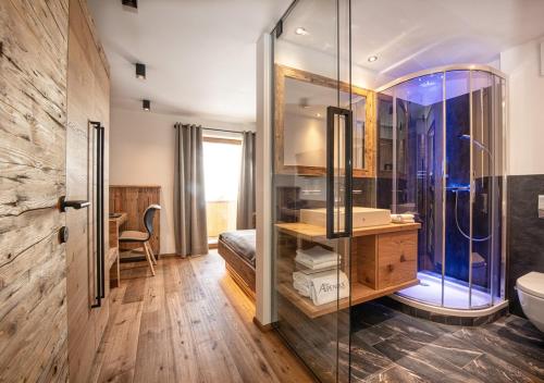 格罗萨尔阿尔卑霍夫酒店的一间带玻璃淋浴和水槽的浴室