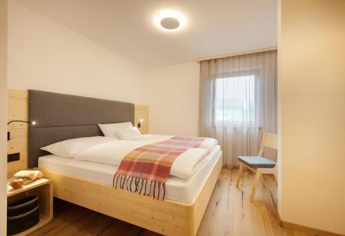 法尔泽斯Ariala Apartments的一间卧室设有一张大床和一个窗户。