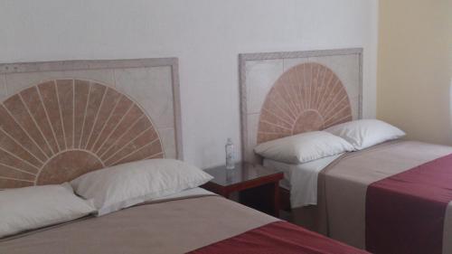曼萨尼约Hotel Albatros Palace的客房设有两张床、一张桌子和两张床。