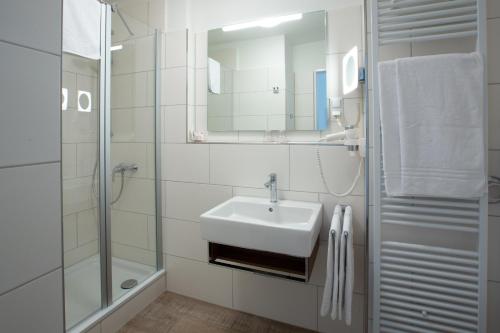 汉堡Stadthaushotel Hamburg - Inklusionshotel的白色的浴室设有水槽和淋浴。