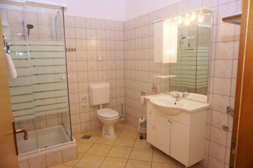 伊穆尼Olive House的浴室配有卫生间、盥洗盆和淋浴。