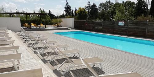 普罗旺斯艾克斯Sweet Home studio Aix en Provence, terrasse, piscine, resto,的一个带椅子的甲板和一个游泳池